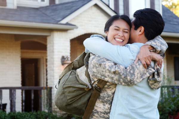 Military woman hugging spouse
